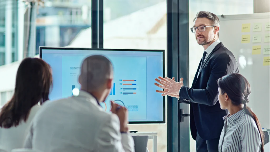 Teammeeting im Büro mit Präsentation von Diagrammen zur Bestandsanalyse und strategischen Auswertung von Unternehmensdaten.