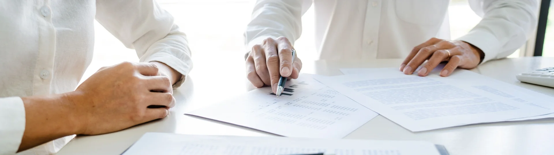 Berater besprechen Finanzunterlagen und Kennzahlen am Tisch, analysieren Dokumente gemeinsam im Rahmen einer strategischen Beratung für ProKanzlei.